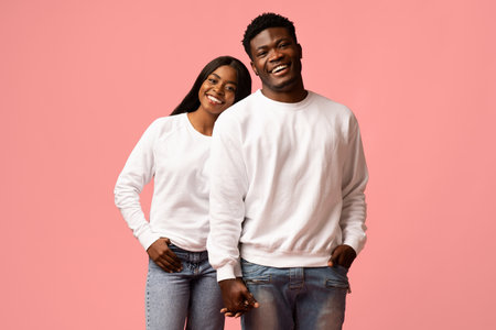 Joyful African American Couple Smiling and Holding Hands in a Pink Studio Setting