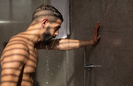 Young Man Enjoys a Hot Shower in a Modern Bathroom for Relaxation and Hygiene