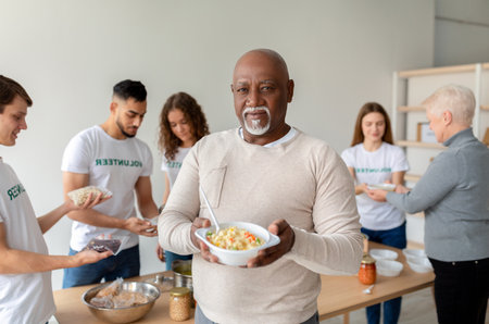Happy Senior Man Benefits From Food Donation in Charity Office With Helpful Volunteers Presentの写真素材