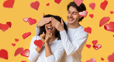 Romantic Surprise Moment Between a Couple With Hearts on a Yellow Backgroundの写真素材