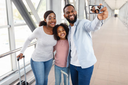 Black family traveling, taking selfie in airportの写真素材