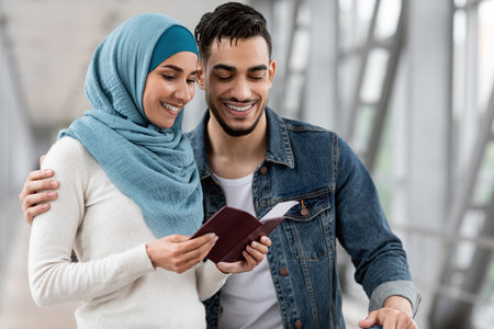 Happy Islamic Spouses Checking Passports And Tickets While Waiting Flight At Airportの写真素材