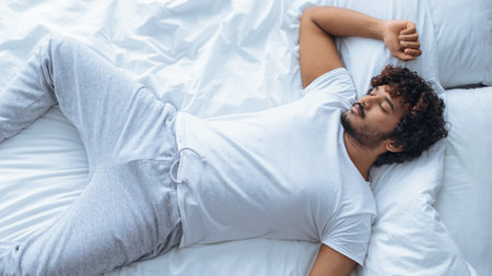 Man Resting on Bed at Home During Early Morning in Casual Clothes
