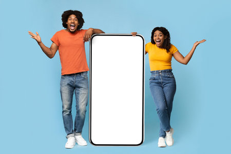 Thrilled african american man and woman with big cellphone, mockup