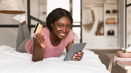 African Woman Shopping Online With Credit Card And Laptop Indoors
