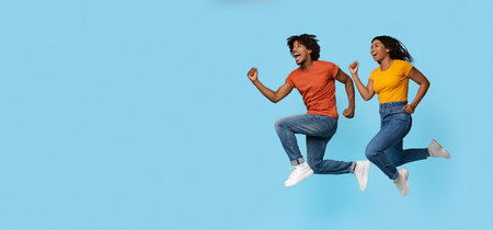 Excited african american lovers jumping upの写真素材