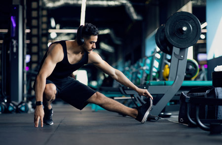 Handsome Young Middle Eastern Male Athlete Warming Up Before Training At Gym