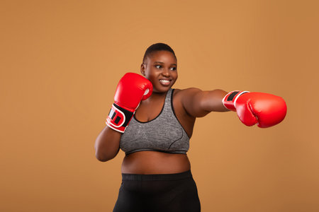 Young Black Woman Boxing Wearing Red Gloves Throwing Punch
