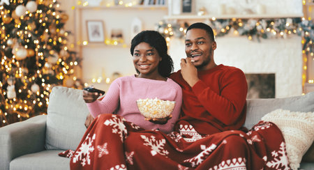 Couple Enjoys Movie Night With Popcorn on Sofa During Winter Seasonの写真素材