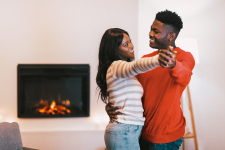 Couple Dancing Together in a Cozy Room Near a Fireplace During a Quiet Eveningの写真素材