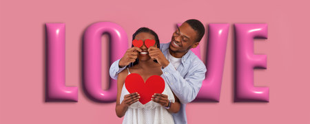 Couple Enjoying Togetherness While Holding Hearts in Front of a Love-Themed Backgroundの写真素材