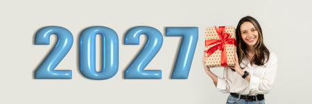 Celebrating the Arrival of 2027 With a Gift in Hand and a Big Smileの写真素材