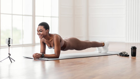 Young black woman planking in front of smartphone
