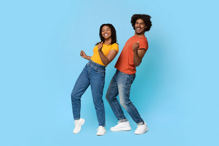 Positive african american couple posing on blue, dancingの写真素材