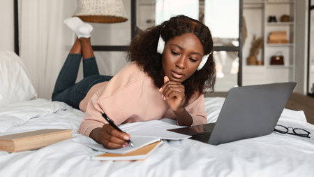 Black Woman Learning Using Laptop Taking Notes At Homeの写真素材