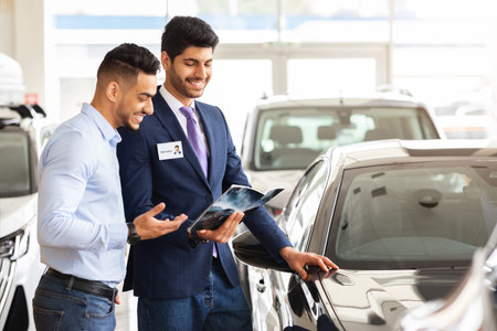 Handsome arab man having conversation with sales assistant in showroomの写真素材