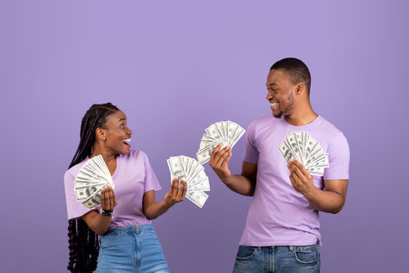 Excited African American couple holding a lot of money