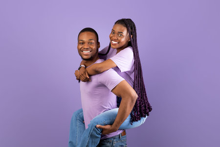 African American man giving piggyback ride for his ladyの写真素材