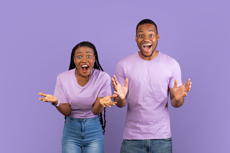 Portrait of excited young black couple hearing great news
