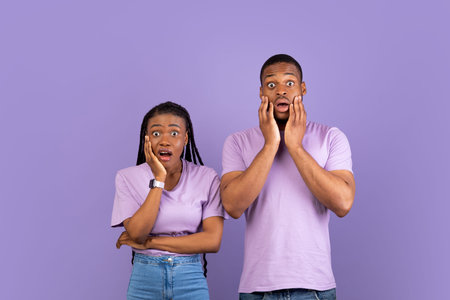 Scared shocked African American couple looking at camera
