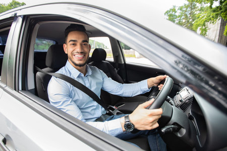 Handsome arab businessman driving car, shot from outside