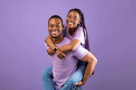 African American man giving piggyback ride for his woman