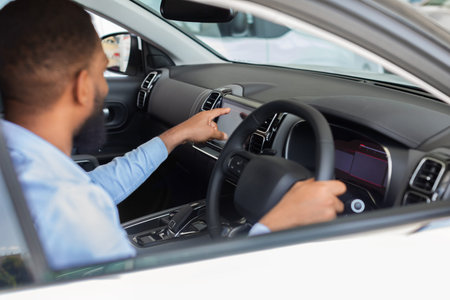 Black Man Choosing New Car In Auto Salon, Touching Multimedia Screen