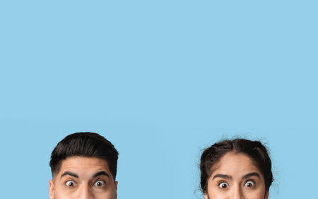 Surprised Expressions of a Young Man and Woman Against a Blue Background During a Casual Moment