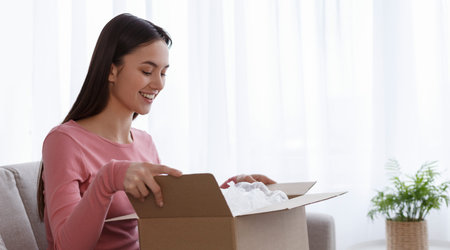 Cheerful woman customer receive and unpacking parcel looking inside