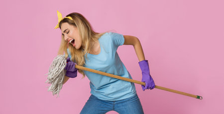 Rock star at home concept. Woman singing a mop