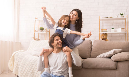 Joyful Young Family Of Three Fooling Together At Home, Having Funの写真素材