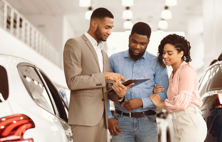 Spouses Buying Car Consulting With Dealer Guy In Dealership Store