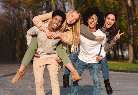 Teens making piggybacks and posing at parkの写真素材