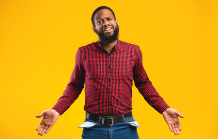 Portrait of black guy showing his empty pocketsの写真素材
