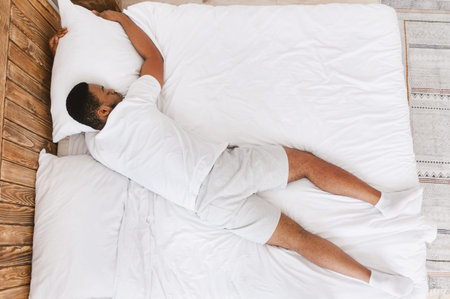 Unrecognizable Black Guy Sleeping Lying On Stomach In Bed Indoor