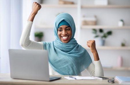 Great News. Happy Excited Black Muslim Lady Celebrating Success With Laptopの写真素材