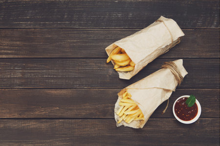 Fries and potato wedges wrapped takeaway at woodの写真素材