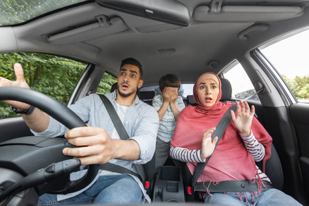 Scared shocked husband, wife in hijab and child with closed eyes in car cabin during incident, free...