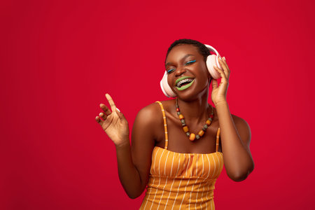 Joyful black lady listening to music, using wireless headphones