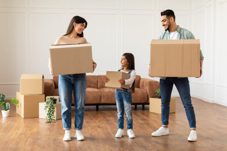 Happy young family holding boxes in new flatの写真素材