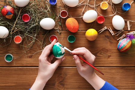 Creative Activity With Colorful Eggs Being Painted on a Wooden Table With Art Supplies