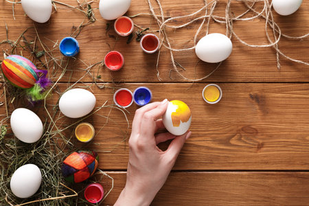 Decorating Easter Eggs With Vibrant Colors on a Rustic Wooden Table