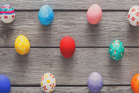 Colorfully Decorated Easter Eggs Arranged on Weathered Wooden Surface for Spring Celebration