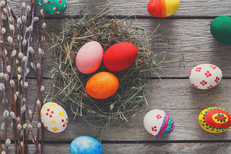 Colorful Easter Eggs Arranged Around a Nest on a Wooden Surface During Springtime Festivities