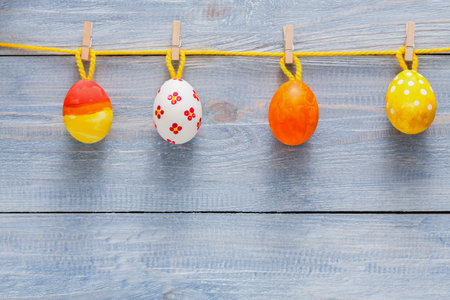 Colorful Decorative Eggs Hanging on a Clothesline for Spring Festivitiesの写真素材