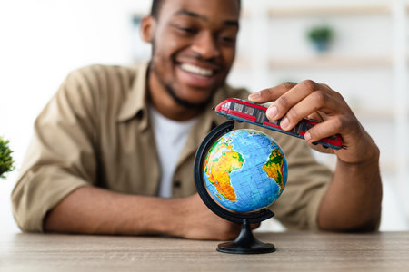 African Man Playing With Train Model And World Globe Indoorsの写真素材