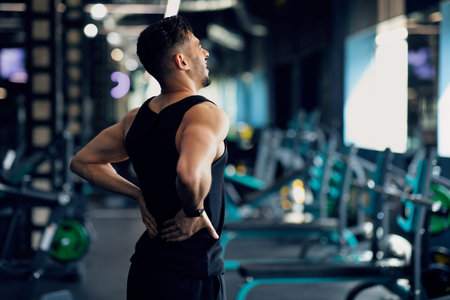Portrait Of Young Arab Bodybuilder Suffering Lower Back Pain At Gym