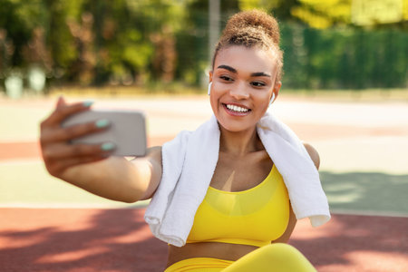 Black lady making selfie photo on smartphone during workout break