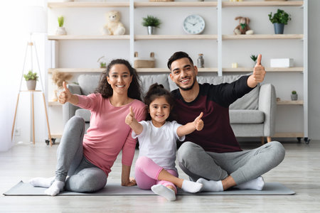 Sporty cute family exercising all together at homeの写真素材