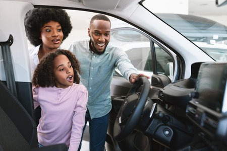 Excited black family looking into car salon, selecting new automobile at dealership, copy space